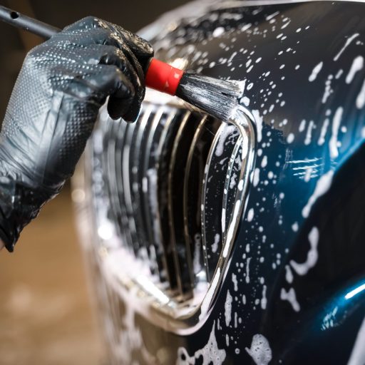 detailing-center-worker-cleans-car-s-radiator-grill-with-brush-min